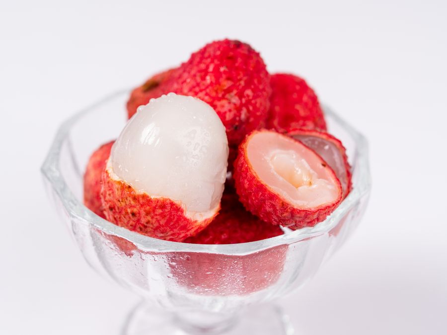 ガラスの器に盛った、皮をむいたばかりの半透明の生ライチ